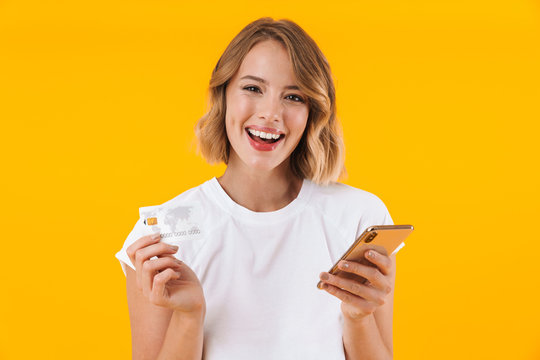 Image of content blond woman holding smartphone and credit card