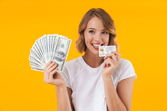 Image of excited blond woman holding money cash and credit card