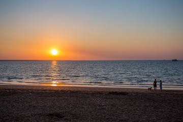 Sonnenuntergang am Strand mit Paar und Hund