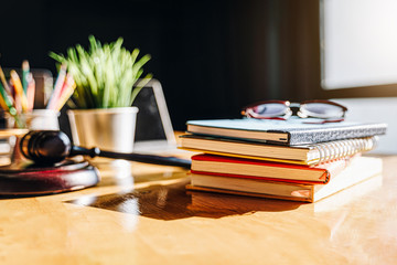 Colorful notebooks with glasses and hammer of a judge on wooden table.law firm concept