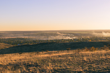 Smoke over the village in the autumn. Burning foliage in Ukraine.