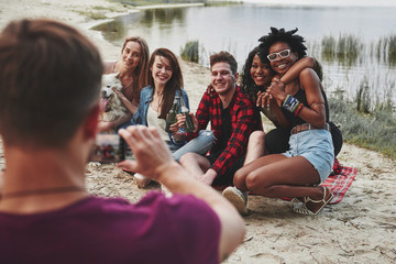 Sincere smiles. Group of people have picnic on the beach. Friends have fun at weekend time