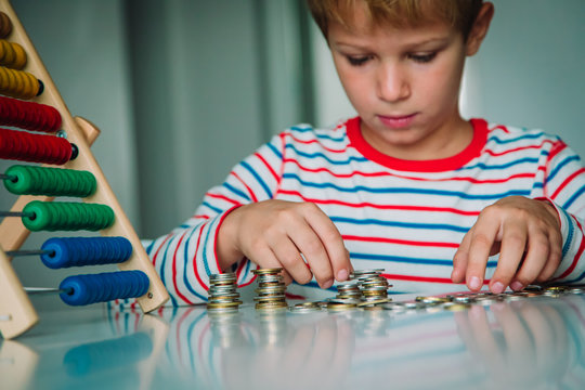child counting money and make tower from coints, boy make savings