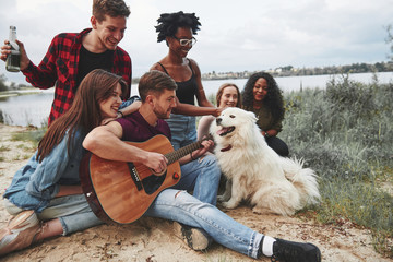 Fototapeta premium Diversity of people. Having picnic on the beach. Friends have fun at weekend time
