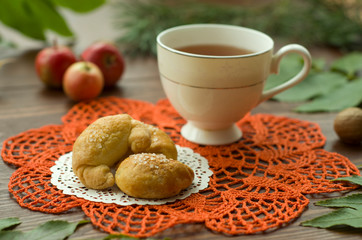  A cozy warm cup of delicious tea with homemade cookies on a wooden and foliage background