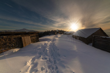 Beautiful winter landscapes from the Ukrainian Carpathian Mountains with traumatic skies and tourists, traveling on ridges