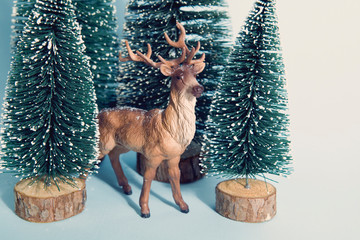 Vintage snowy forest firs and reindeer