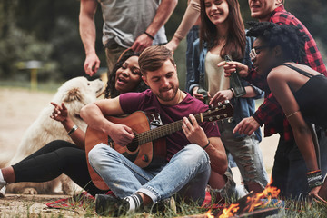 Weekend time. Group of people have picnic on the beach. Friends have fun