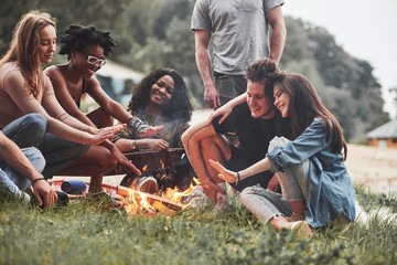 On vacation. Group of people have picnic on the beach. Friends have fun at weekend time