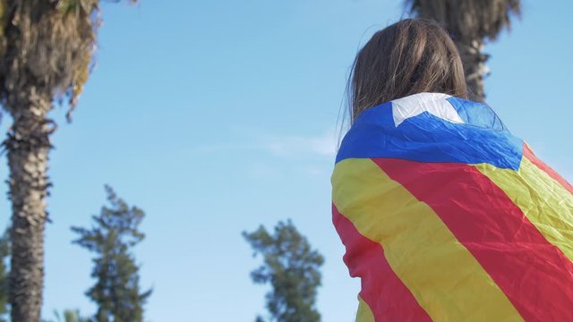 A girl with the Catalan Flag on her back During the protests claiming Freedom for Political Prisoners in Catalonia. Barcelona Spain
