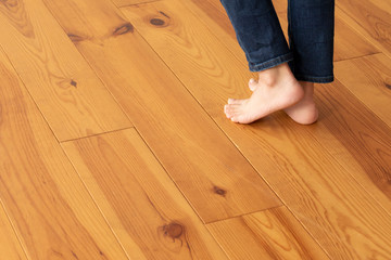 木目の床と若い女性の足元のアップ