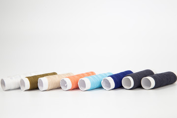 The threads of different colorful with the coils on a white background.