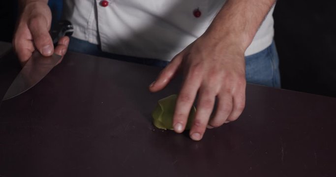 Cutting of an avocado by a chef in white uniform, 4k