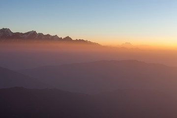 Misty landscape in the Himalayas. Foggy mountain ridges at sunrise. Amazing view on the Everest Base Camp trail.