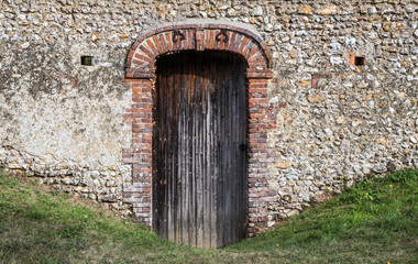 Fototapeta na wymiar side entrance wooden door of old castle in rural France