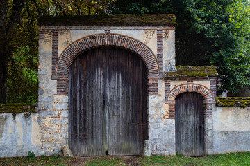 Fototapeta na wymiar Large and small castle doors entrance in rural France