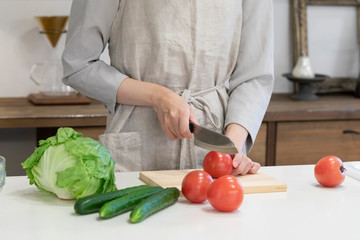 キッチンで野菜を切る若い女性の手元