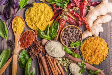 Heaps of various ground spices on wooden background. Georgian spices, Indian spices, Arabian...