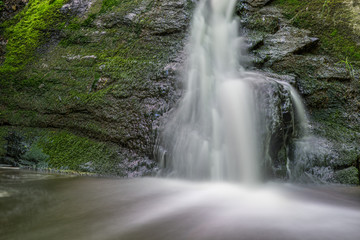 waterfall cascades over mossy rocks