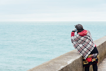 une femme photographie l'océan
