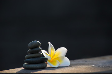 Frangipani flower and stack of zen stones