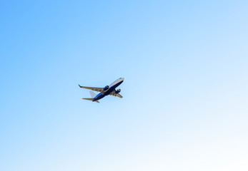 Fototapeta na wymiar Big passenger plane flies in clear blue sky Aeroplane high up voyage