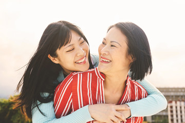 Happy Asian mother and daughter having fun outdoor - Chinese family people spending time together outside - Love, relationship and parenthood lifestyle concept - Powered by Adobe