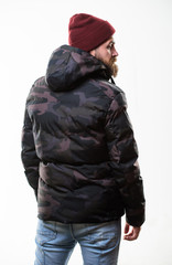 Hipster winter fashion. Guy wear hat and black winter jacket. Comfortable winter outfit. Winter stylish menswear. Man stand warm camouflage pattern jacket parka with hood isolated on white background © be free