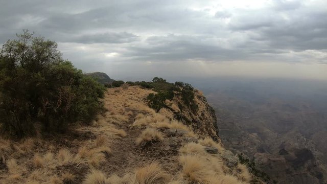 Hiker walking along the edge in the top of Simien mountains trail, First person point of View. Semien Mountain, Ethiopia wilderness, Africa