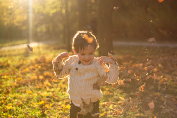 Happy little child baby boy laughing and playing in the autumn