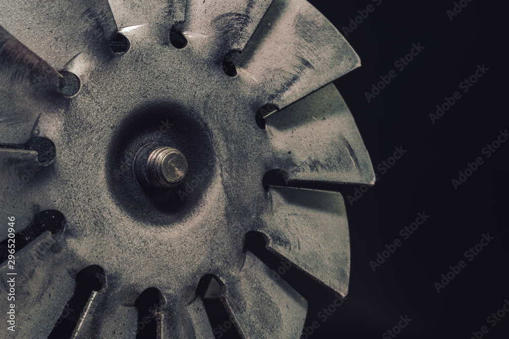 Poster close up old electric motor impeller on a dark background. macro view.