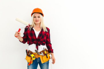 Young happy woman painting interior wall with paint roller in new house