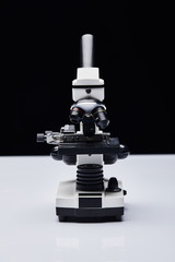 modern microscope on white table isolated on black