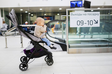 Baby in stroller near an escalator at airport