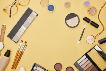 top view of necklace near decorative cosmetics isolated on yellow