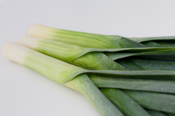 Fresh green leeks in a white background. Close up