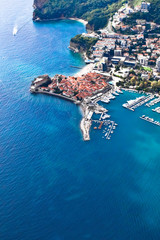 Red city (roofs) Budva and the port among the sea, photo from above. landscape below (aerial photo from a paraglider) with the coast and the blue sea, Montenegro