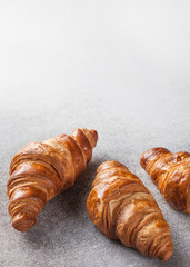 three croissants on grey stone background