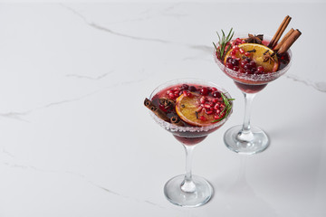 christmas cocktail with orange, pomegranate, cinnamon on marble table