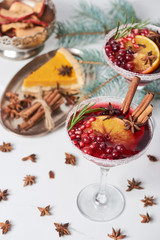 selective focus of christmas cocktails with orange, pomegranate and cinnamon