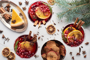 top view of christmas cocktails with orange, pomegranate, cinnamon, dry apples and pie