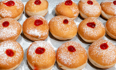 Fresh donuts  with jelly  at the bakery display for Hanukkah celebration. Selective focus.