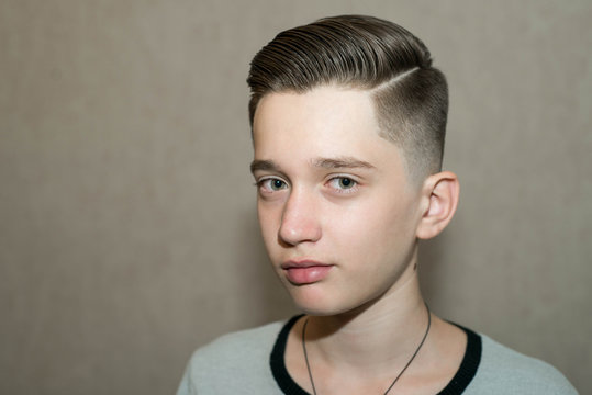 Stylish modern retro haircut side part with mid fade with parting of a  school boy guy in a barbershop on a brown background Stock Photo | Adobe  Stock