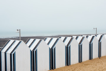 Naklejka premium Des cabines de plage en Normandie. Des cabines de plage bleues et blanches. Une plage du nord de la France