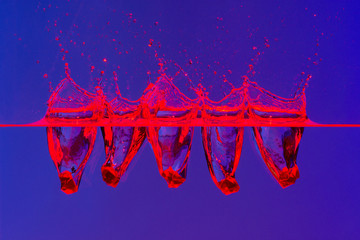 Beautiful and cool splashes of water from falling into it red transparent crystals