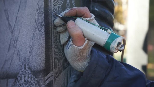 The master manually engraves the icon on the stone