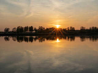 beautiful sunset by the lake, foggy sky, autumn evening