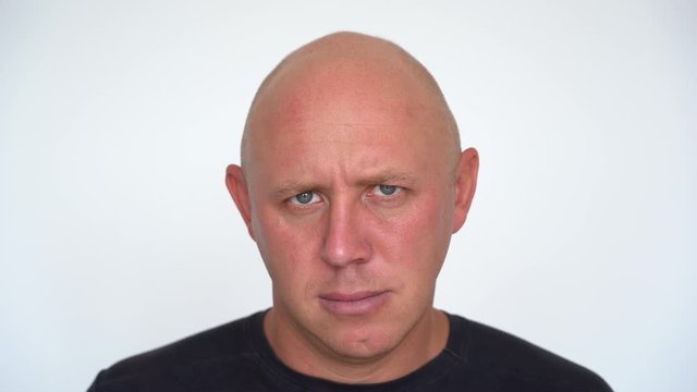 Closeup shoot of middle-aged caucasian bald man looking at camera. People and lifestyle concept. Portrait of middle aged man indoors