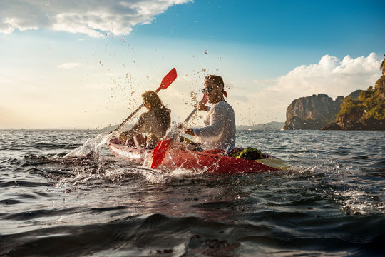 Happy Couple Having Fun And Walks On Kayaks