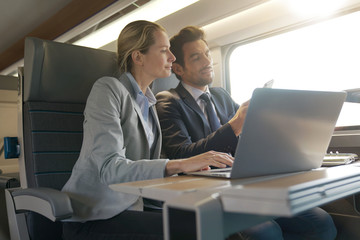two colleagues working on a train